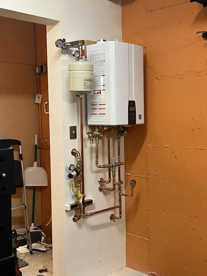 Plumbing technician inspecting water heater connections in Duncan